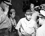 United States Navy Commander Hiram Cassedy (left) and Japanese Navy Commander Toshio Kusaka (center) on the deck of the Japanese submarine I-400 alongside USS Proteus, Sagami Bay, Japan, 28 Aug 1945.