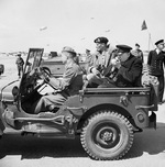 Winston Churchill seen lighting his cigar as he and General Bernard Montgomery tour inland locations during the Normandy campaign, 12 Jun 1944.