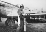 Australian Air Force armorer cleaning the bore of a .50 caliber machine gun in the wing of a RAAF 77 Squadron P-51D Mustang in Korea, 1951. Note the HVAR air-to-surface rockets mounted under the wing.