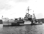 Cruiser USS Honolulu at Tulagi, Solomon Islands, late Apr 1944. Note men painting near the waterline and the two LCVPs alongside.