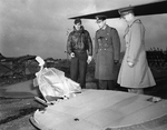 King George VI of the United Kingdom (center) on a tour of RAF Thurleigh in Bedfordshire, England, 13 Nov 1942. He is hearing from USAAF Lt Robert Riordan (left) about how his B-17 Fortress was damaged on a mission.