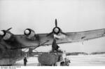 German Air Force mechanic performing maintenance on the outboard engine on the port side wing of a Me 323 Gigant aircraft, Soviet Union, early 1943, photo 1 of 2