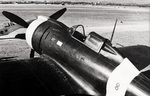 Close-up view of the front half of the fuselage of a Re.2000 Falco I fighter of the Italian 74th Squadron at rest at an airfield, 1940s