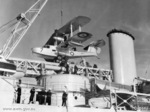 Royal Australian Air Force Walrus aircraft A2-7 being lifted onto a Leander-class light cruiser, 1939