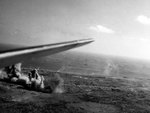 Aerial photo of the Iwo Jima invasion beach, 19 Feb 1945; note landing craft approaching the beach and the wing of a SB2C-4 Helldiver aircraft from carrier Hancock