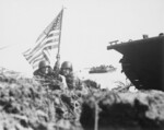 Two US officers plant the first American flag on Guam eight minutes after US Marines and Army assault troops landed on the beaches, 21 Jul 1944