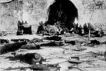 Japanese soldiers transporting loot with a cart at a Nanjing city wall gate, China, Dec 1937; note unburied Chinese remains