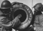 Two Japanese soldiers carrying an unidentified item labeled 