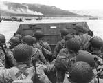 American troops watched activity ashore on Omaha Beach as their LCVP landing craft approached the shore, Normandy, 6 Jun 1944, photo 1 of 2