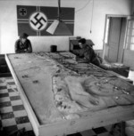 Two Canadian soldiers looking at a German model of defenses at Courseulles-sur-Mer near Juno Beach landing area, Normandy, France, 6 Jun 1944