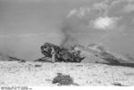 German airborne trooper destroying a crash-landed glider, Gran Sasso, Italy, 12 Sep 1943