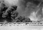 View of the Parade Ground at the Pearl Harbor Marine Barracks, between 0930 and 1130 on 7 Dec 1941, with smoke in the background rising from burning ships, photo 3 of 3