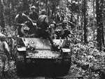 US Marines sitting atop a M3 light tank, Cape Gloucester, New Britain, Bismarck Archipelago, late Dec 1943; note fallen Japanese soldiers