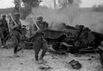 Finnish Army sergeants Kaarlo Niemelä (leading, with panzerfaust and KP/-31) and Heino Nikulassi (with panzerfaust and small arms on his back) during Battle of Tali-Ihantala, north of Viipuri, Karjala, Finland, 30 Jun 1944; note destroyed Russian T-34 tank in background