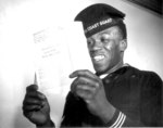 African-American US Coast Guard sailor smiling as he read a letter from home, date unknown