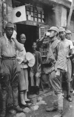 Japanese soldiers taking a break from duty with Chinese civilians, China, circa late 1937 to early 1938