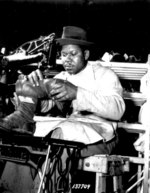 African-American Howard Wilson making a pair of paratrooper boots at a sewing machine in the C & E Shoe Shop at Fort Benning, Georgia, United States, Jul 1942