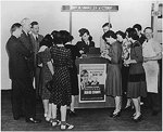 An American woman promoting war bonds and stamps, 1943