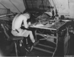 USAAF man working on aerial reconnaissance photographs, Saipan, Mariana Islands, 1945, photo 1 of 2