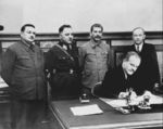 Vyacheslav Molotov signing a pact with Soviet-puppet state Finnish Democratic Republic, Moscow, Russia, 2 Dec 1939; Andrei Zhdanov, Kliment Voroshilov, Joseph Stalin, and Otoo Wille Kuusinen in background