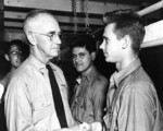 Rear Admiral Richmond Turner congratulating US Marine Corps Private First Class Carl Emanuel Magnuson after Magnuson had just received a Purple Heart medal, aboard a hospital ship at Pearl Harbor, US Territory of Hawaii, 17 Dec 1943