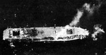 Aerial photo of Unyo showing destroyed bow, Pacific Ocean, 7-8 Feb 1944; note the ship sailing backwards to minimize flooding in the bow section