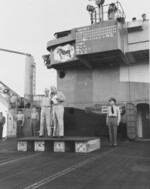 Captain George DeBaun (center) relieving Captain Herbert Taylor (left) as the commanding officer of USS Cowpens, 24 Nov 1944; note Commander Hugh Nieman at right side of photograph