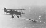 Japanese Navy Type 96 biplane fighter flying over carrier Kaga, off China, 1937-1938