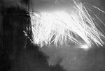 Tracer fire from Allied warships lighting up the sky off Ouistreham, France, 10 Jun 1944; photo taken from HMS Mauritius, seen in foreground