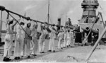 Crewmen of USS Oklahoma cleaning one of the 14-inch guns of the aft turret, circa 1916