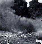 Splinters of teak flight deck surround bomb hole near Ticonderoga