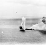 Cruiser Yahagi listing heavily to port, East China Sea, 7 Apr 1945 at 1345 hours; note four American aircraft in flight on the left side of the photograph