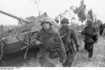 German MG42 machine gun crew passing a wrecked Elefant tank destroyer, Nettuno, Italy, Mar 1944