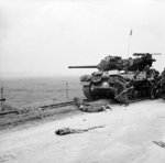 British troops taking shelter near a M10 Wolverine tank destroyer, Normandy, France, 6 Jun 1944