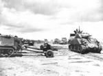 M4 Sherman tanks and halftrack vehicles towing M3 37-mm anti-tank guns on either Omaha or Utah Beach, Normandy, France, 12 Jun 1944