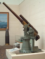 Japanese Type 3 8cm anti-aircraft gun on display at the Yushukan Museum on the grounds of the Yasukuni Shrine, Tokyo, Japan, 6 Aug 2005; note shell for Yamato-class battleships in background