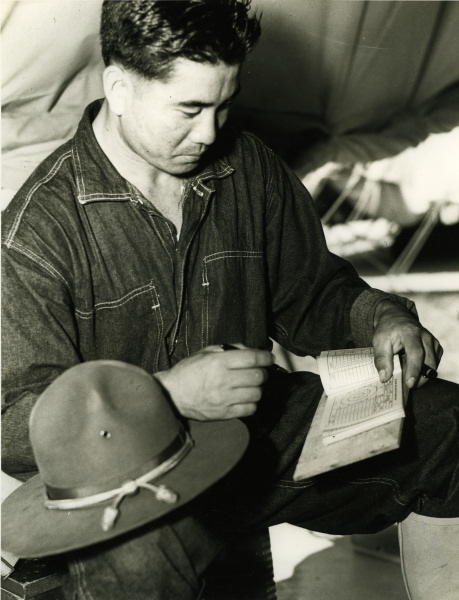 Japanese-American recruit reviewing his daily rifle score record, US Territory of Hawaii, date unknown