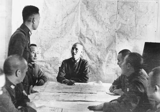 Chiang Kaishek at a military planning session, China, circa 1938-1940; note He Yingqin to Chiang's right