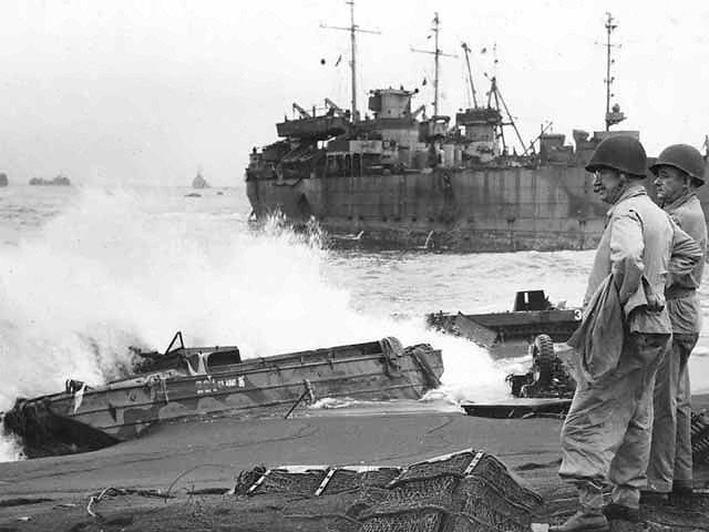 Lieutenant General Holland M. Smith and Colonel Dudley S. Brown surveying wreckages at the Iwo Jima invasion beaches, circa Mar 1945