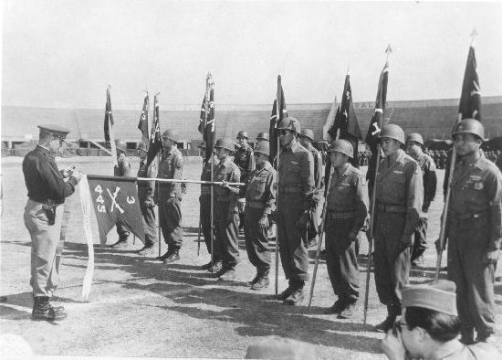 US Army Lieutenant General Lucian Truscott of 5th Army fastening Presidential Unit Citation banner to guidon of 3rd Btn, 442nd RCT, Livorno, Italy, Sep 1945