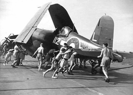 Preparing a Corsair aircraft for flight aboard HMS Glory, off Rabaul, New Britain, 6 Sep 1945