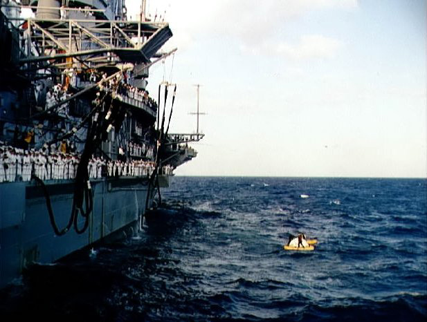 Gemini 3 spacecraft at the side of USS Intrepid awaiting recovery, in the Atlantic Ocean north of Dominican Republic, 23 Mar 1965