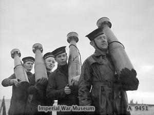 Crewman on HMS King George V with 7-inch anti-aircraft rockets, 1941