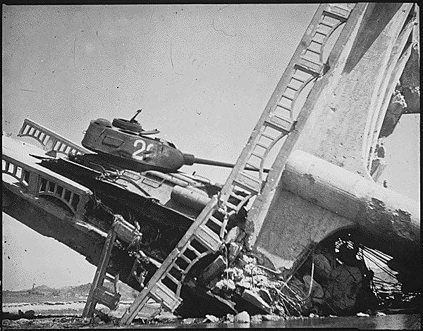 Wreckage of a North Korean T-34/85 medium tank on a bombed out bridge, south of Suwon, Korea, 7 Oct 1950