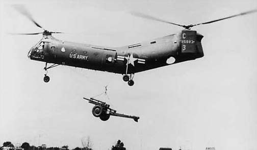 US Army CH-21C Shawnee helicopter transporting M101 105mm howitzer, circa 1960s